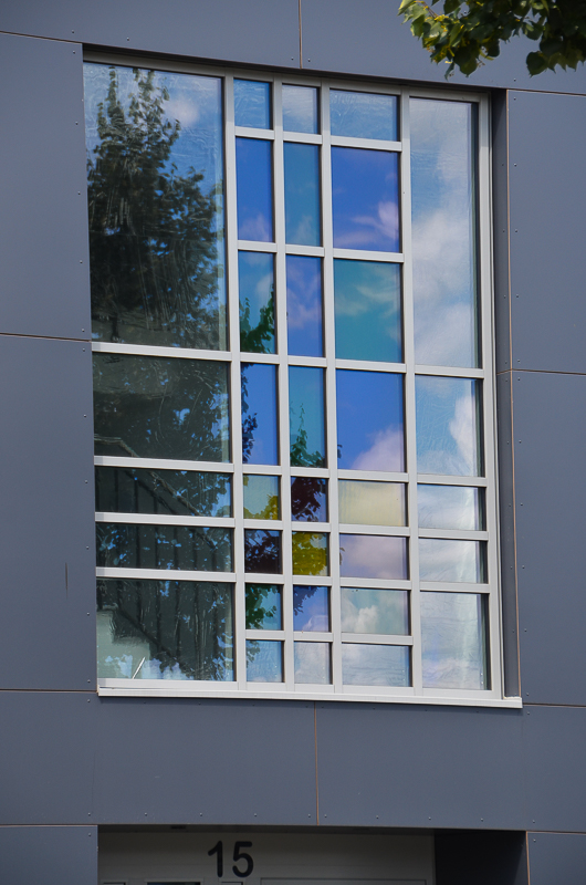 Aluminium-Türelemente Heroal D 72, Aluminium Pfosten-Riegel-Fassade Heroal C 50 HI mit geometrischer Sprossenaufteilung und farbigen Gläsern